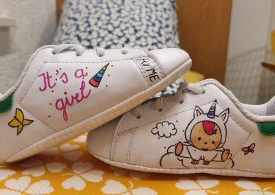Dessin sur chaussures de bébé pour cadeau de naissance. Petite licorne avec inscription it's a girl. création par Lorraine Ryser pour RyLookMe
